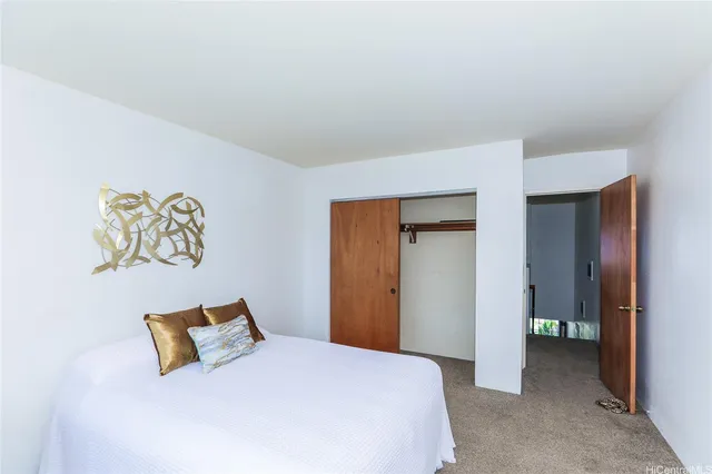 a bedroom with a bed and painting on the wall