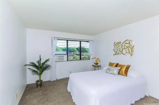 a bedroom with a bed and a potted plant