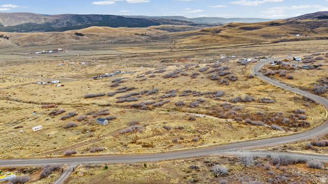 349 West Mountain View Road, Unit 349 Fairview, UT 84629 - Photo 3 of 26 Extensive undeveloped land featuring a winding paved road, scattered low-lying vegetation, and distant rolling hills