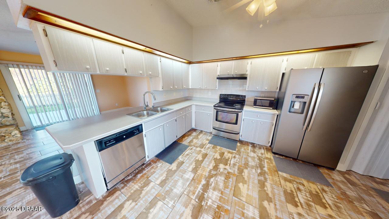 2219 Umbrella Tree Drive Edgewater, FL 32141 - Photo 4 of 22 a kitchen with granite countertop a refrigerator and a sink