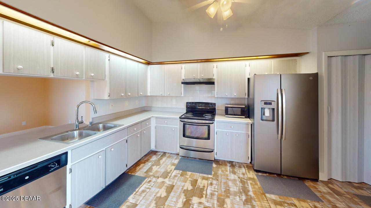 2219 Umbrella Tree Drive Edgewater, FL 32141 - Photo 5 of 22 a kitchen with a sink cabinets stainless steel appliances and a window