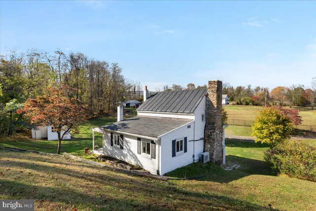 a view of a house with a big yard and large trees