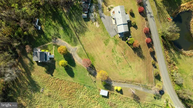 an aerial view of residential houses with outdoor space and trees