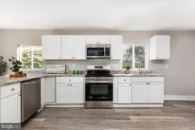a kitchen with stainless steel appliances granite countertop a stove and a sink