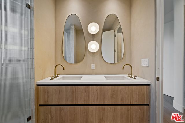a bathroom with a double vanity sink mirror and shower