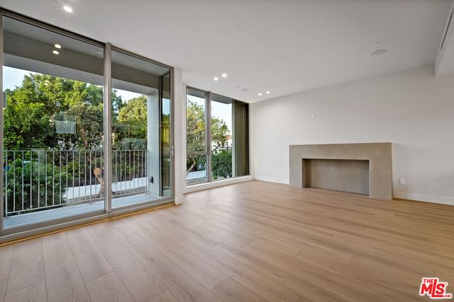 a view of empty room with wooden floor and fireplace