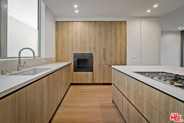 a kitchen with sink a stove and a refrigerator