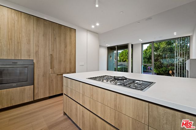 a kitchen with a wooden floor and a refrigerator