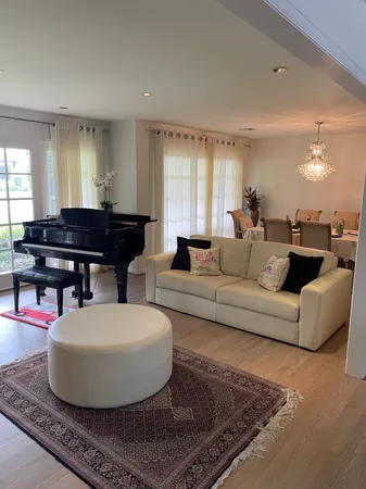 a living room with furniture and a piano
