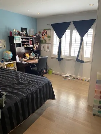 a bed sitting in a bedroom next to a window