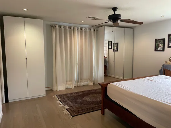 a spacious bedroom with a bed and a chandelier
