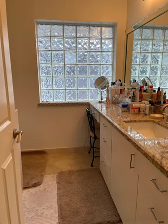 a bathroom with a granite countertop sink and a mirror