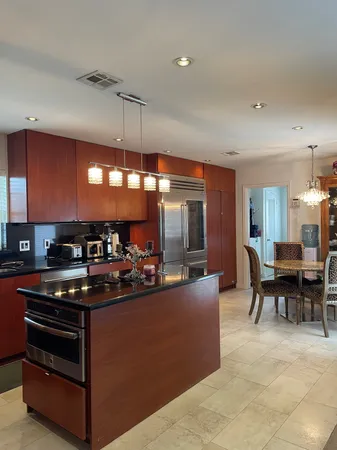 a kitchen with stainless steel appliances kitchen island granite countertop a stove and a sink