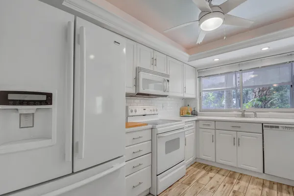 a kitchen with white cabinets and white appliances