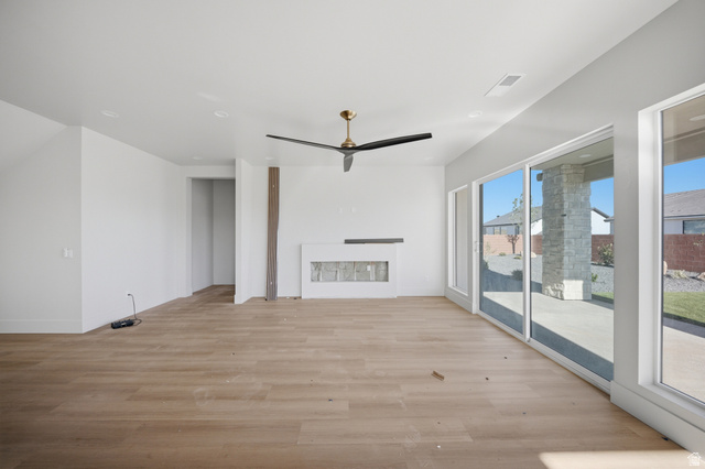 3011 East Rimrunner Drive, Unit 302 St. George, UT 84790 - Photo 17 of 45 Unfurnished living room with light wood finished floors, a fireplace, and ceiling fan
