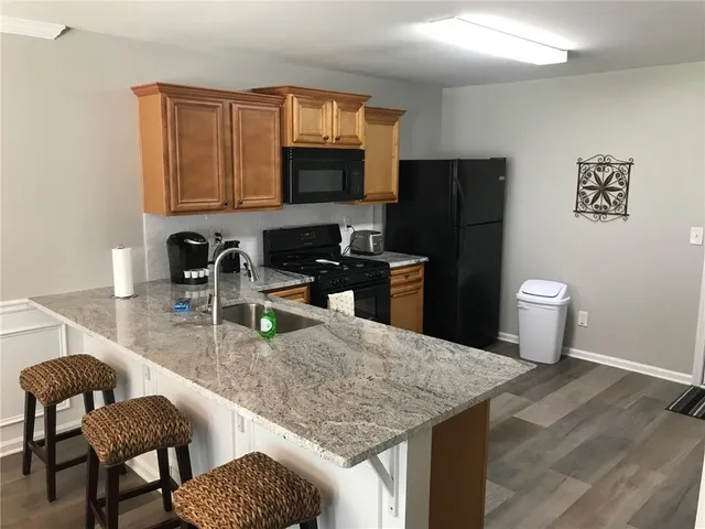 a kitchen with a granite countertop sink and stove