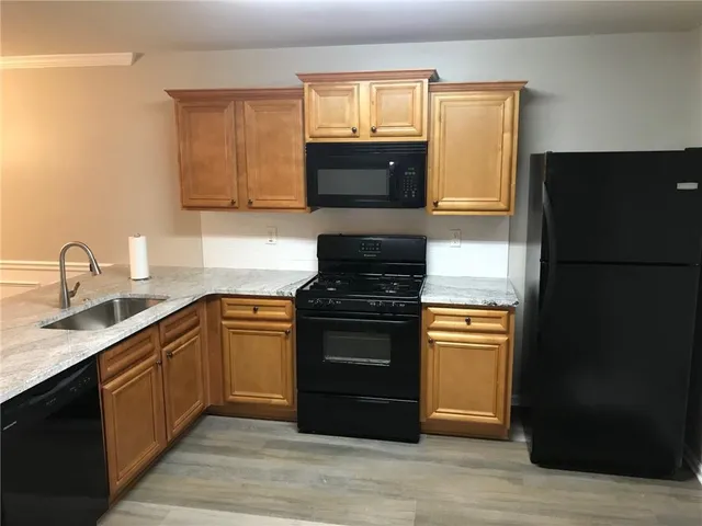 a kitchen with granite countertop a refrigerator stove and sink