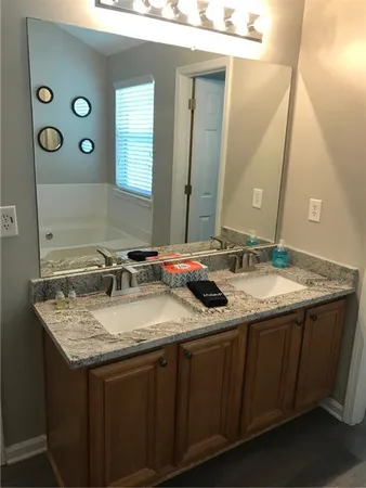 a bathroom with a granite countertop sink and a mirror