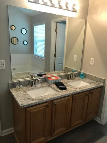 a bathroom with a granite countertop sink and a mirror