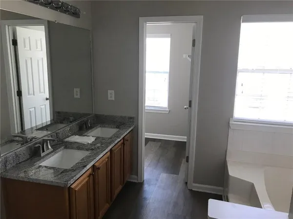 a bathroom with a granite countertop sink and a mirror