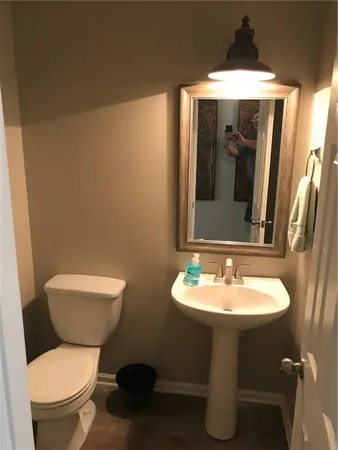a bathroom with a toilet sink and mirror