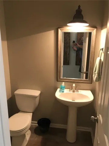 a bathroom with a toilet sink and mirror