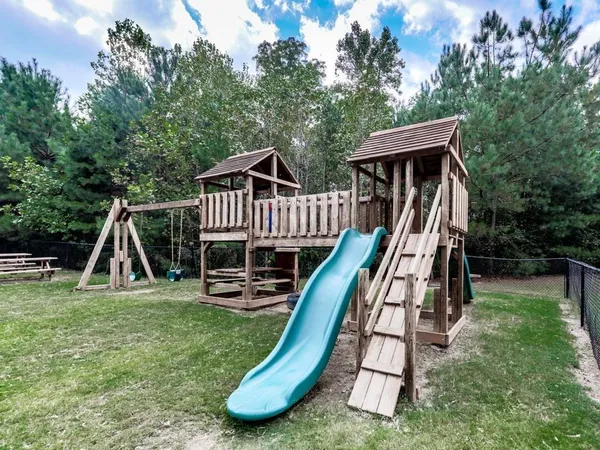 a view of a house with a slide and wooden deck