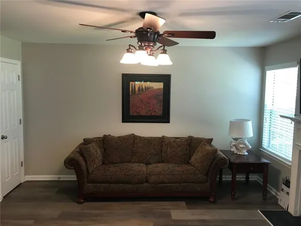 a living room with furniture a chandelier and a window