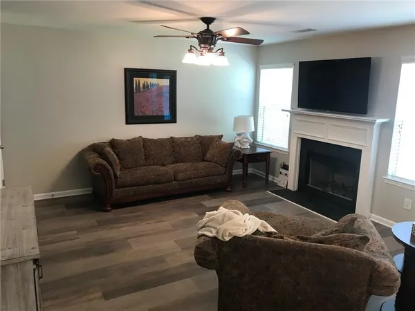a living room with furniture a flat screen tv and a fireplace