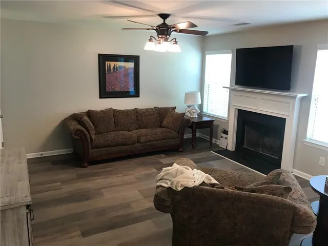 a living room with furniture a flat screen tv and a fireplace