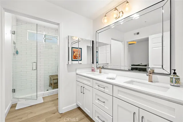 a bathroom with a double vanity sink mirror and shower
