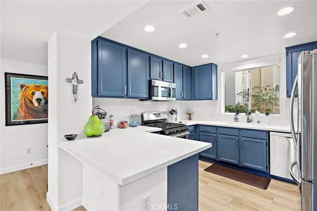 a kitchen with a sink a stove a refrigerator cabinets and wooden floor