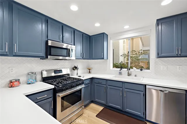 a kitchen with a sink stove top oven and cabinets