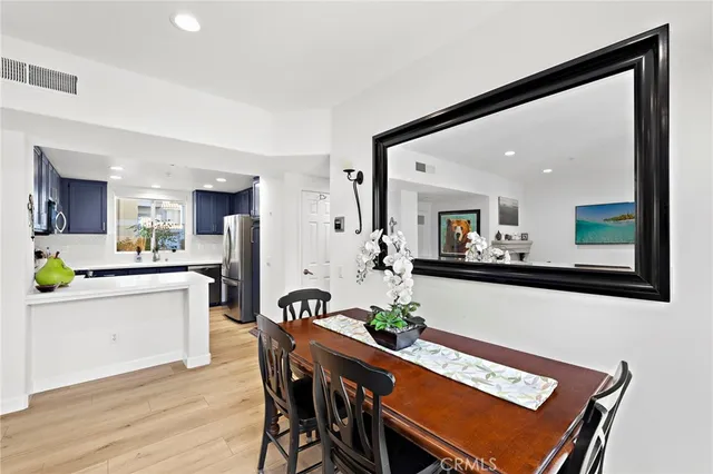 a kitchen with stainless steel appliances kitchen island granite countertop a table and chairs in it