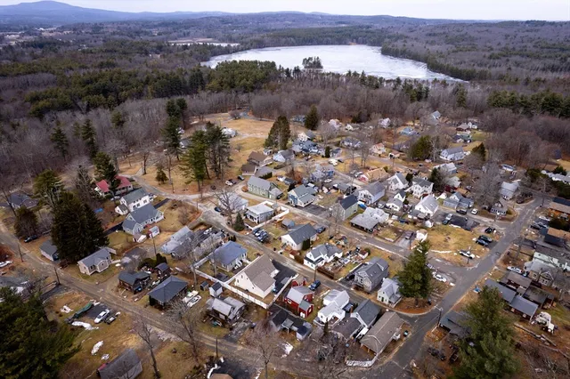 an aerial view of a city with lots of residential buildings and mountain view in back