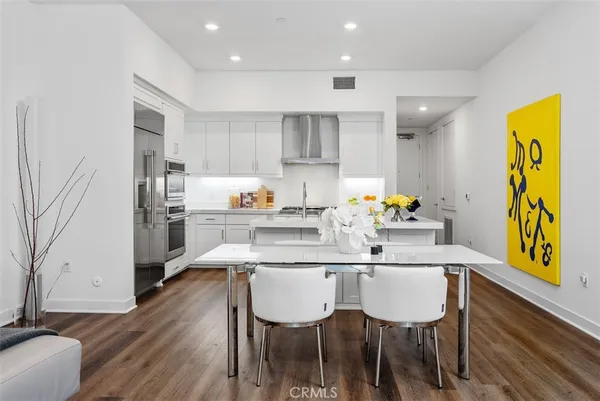 a kitchen with stainless steel appliances white cabinets and wooden floor