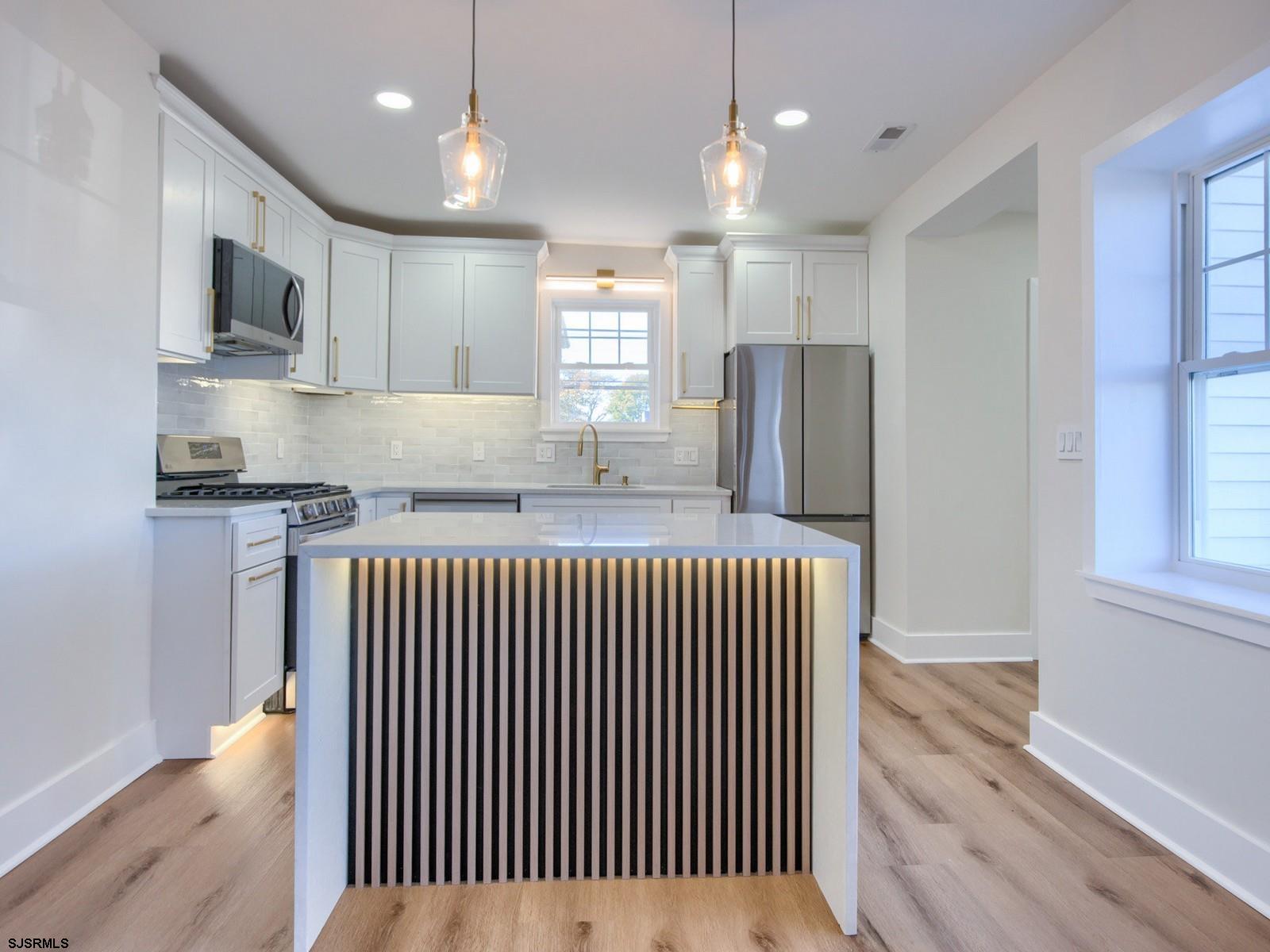 706 Augustine Road Atlantic City, NJ 08401 - Photo 12 of 56 a kitchen with stainless steel appliances granite countertop a refrigerator oven a sink dishwasher and white cabinets with wooden floor