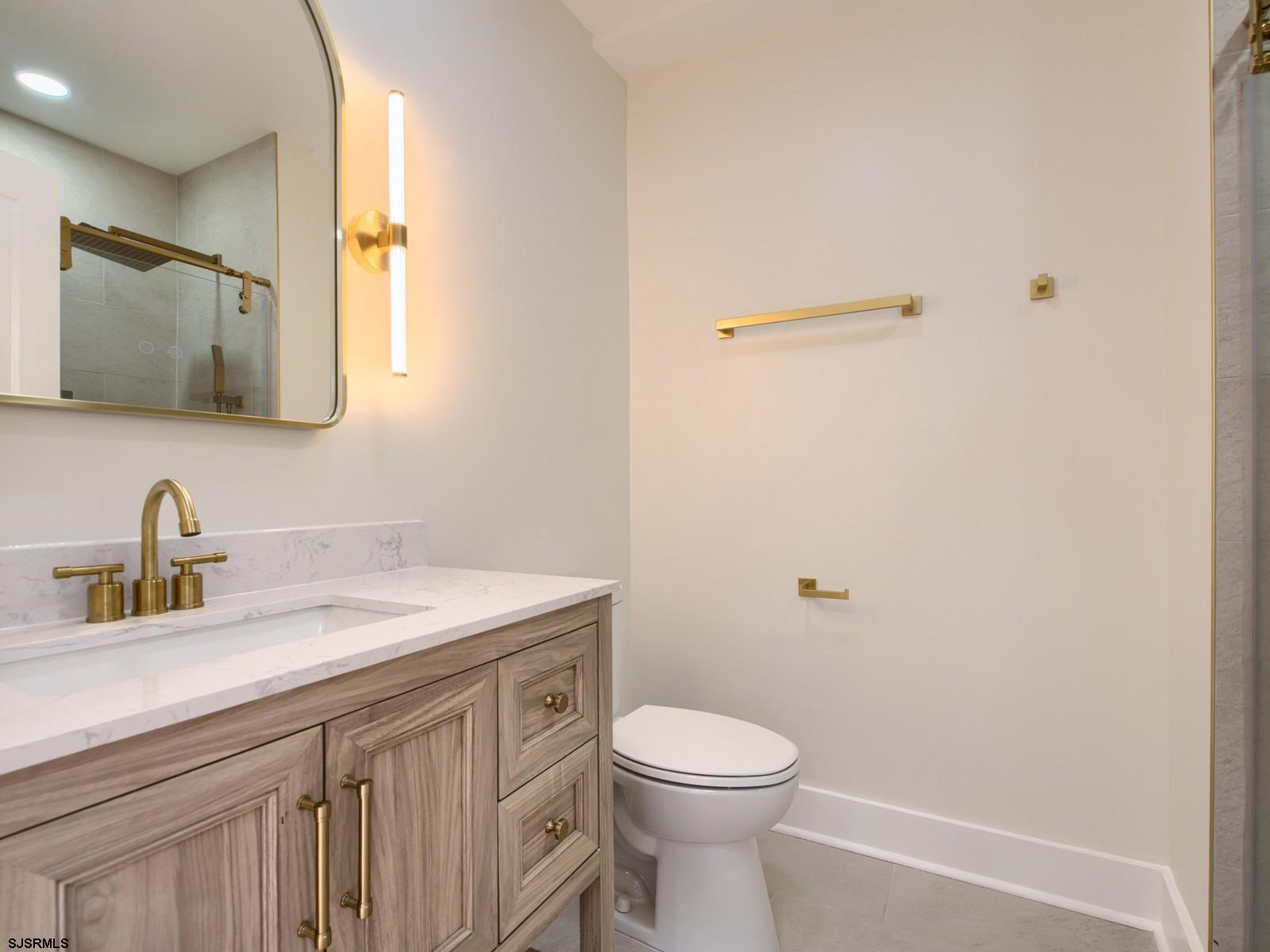 706 Augustine Road Atlantic City, NJ 08401 - Photo 19 of 56 a bathroom with a granite countertop sink a toilet and a mirror