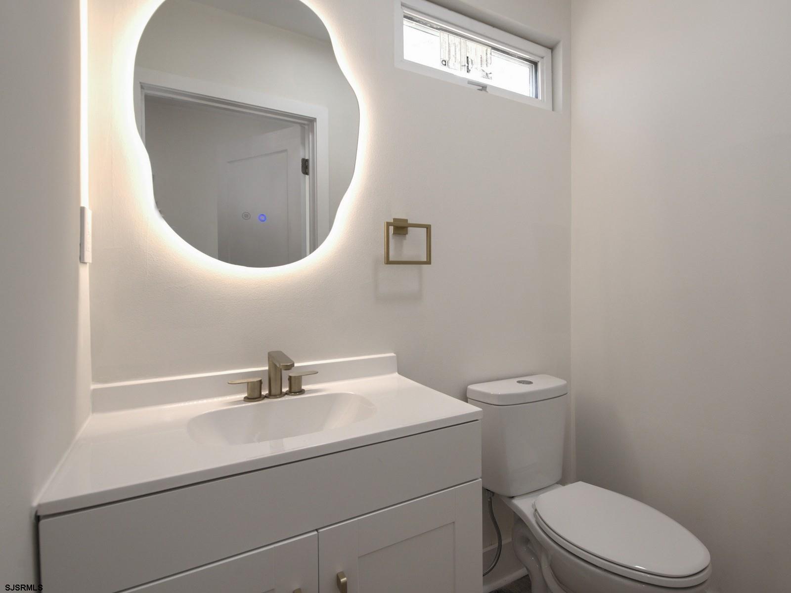 706 Augustine Road Atlantic City, NJ 08401 - Photo 22 of 56 a bathroom with a toilet a sink and mirror