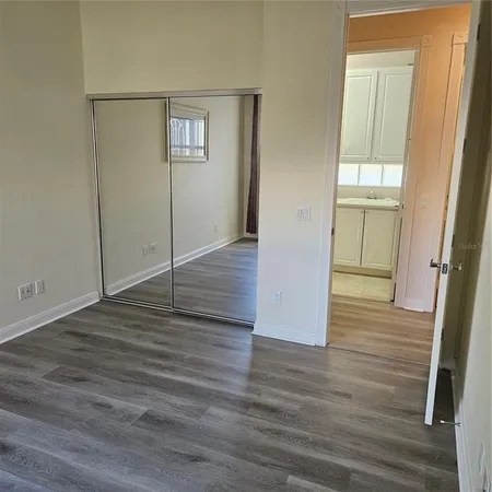 an empty room with wooden floor and entrance