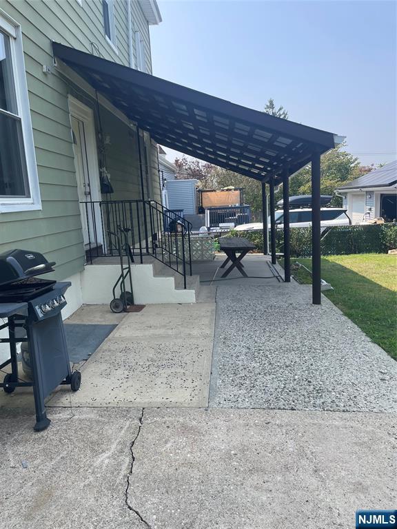 508 2nd Street, Unit 1 Carlstadt, NJ 07072 - Photo 14 of 41 a view of a backyard with table and chairs under an umbrella
