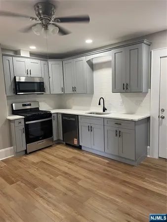 a kitchen with stainless steel appliances a stove a refrigerator and a sink