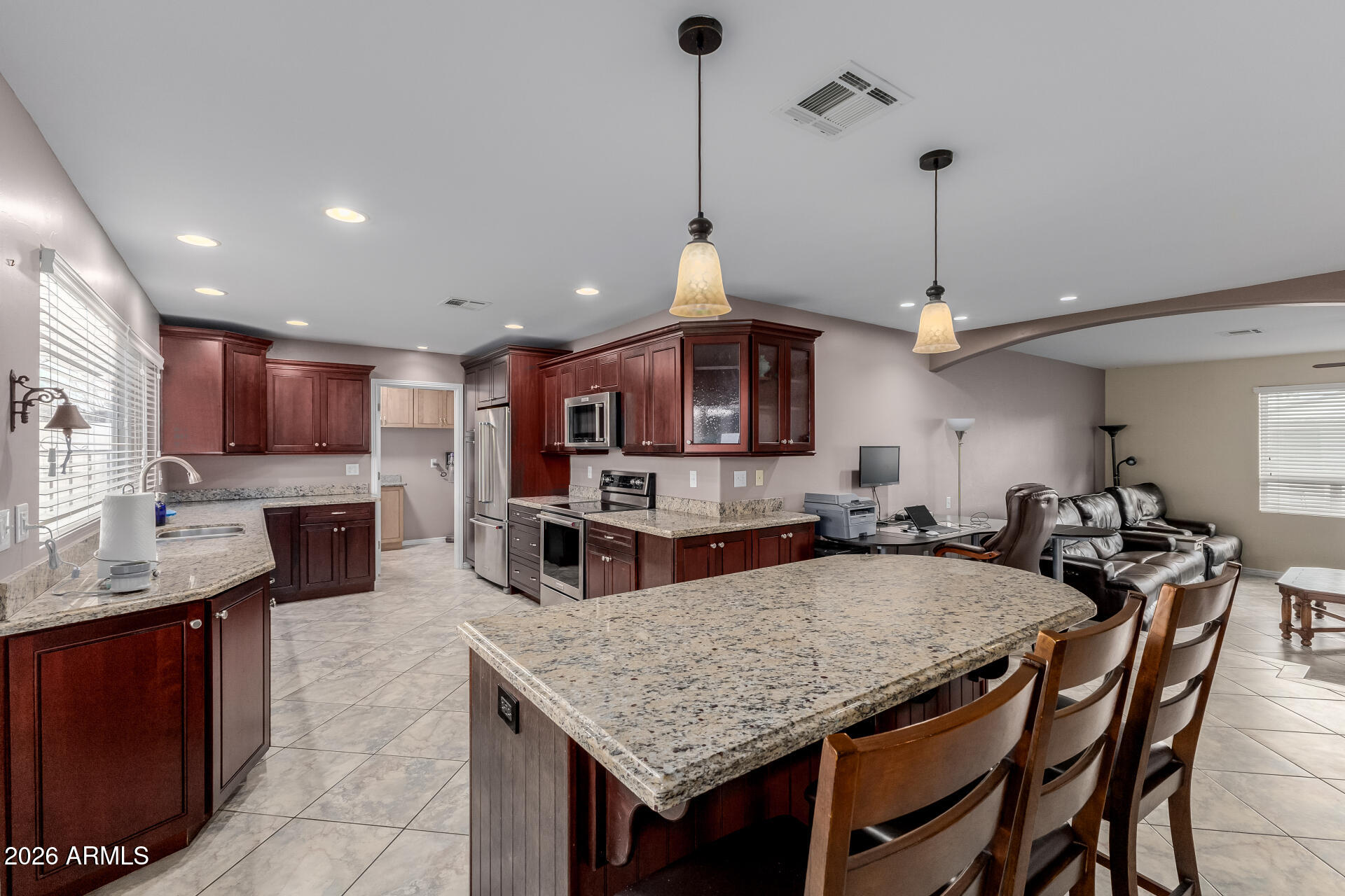 802 West Caribbean Lane Phoenix, AZ 85023 - Photo 22 of 47 a kitchen with stainless steel appliances granite countertop a kitchen island a stove a table and chairs