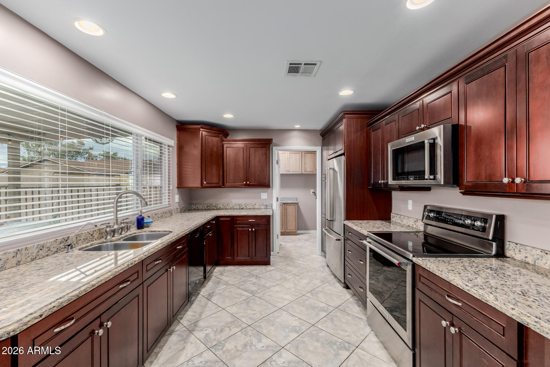 802 West Caribbean Lane Phoenix, AZ 85023 - Photo 23 of 47 a large kitchen with stainless steel appliances granite countertop a sink stove microwave and cabinets