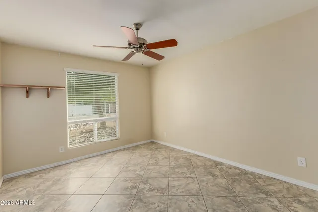 an empty room with closet and ceiling fan