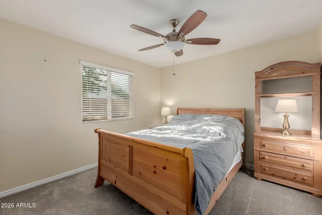 a bedroom with a large bed and a chandelier fan