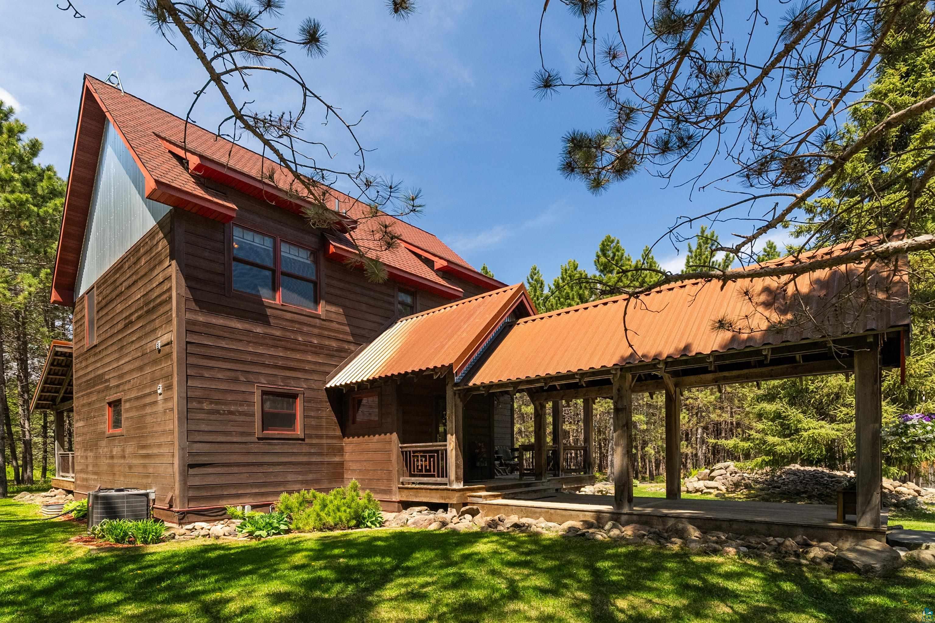 75 East Stark Road Esko, MN 55733 - Photo 55 of 87 Wood-sided residence featuring a red metal roof and an extended covered porch with wood posts