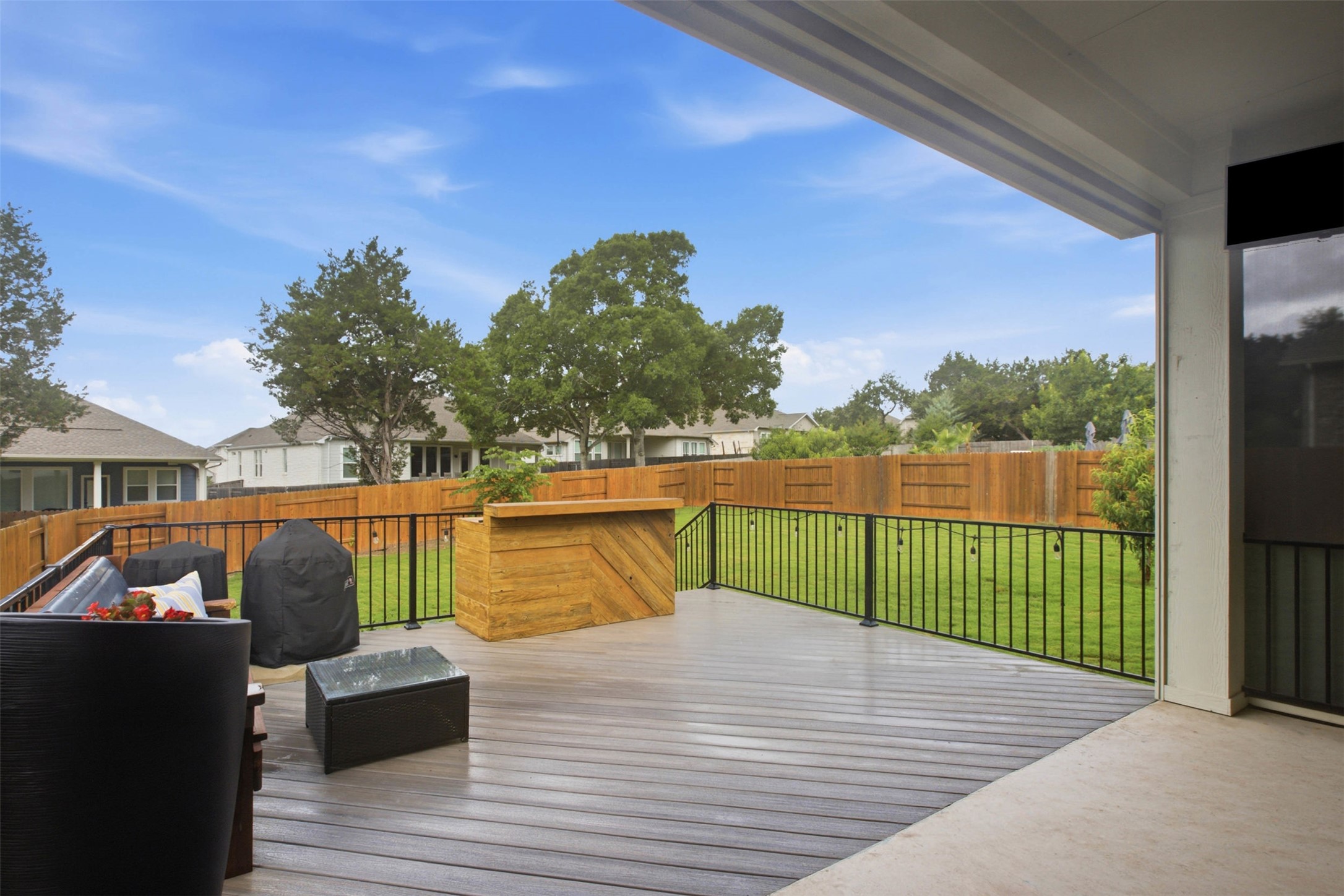 1113 Modoc Way Kyle, TX 78640 - Photo 28 of 34 A spacious outdoor deck with sturdy railings overlooks a verdant lawn.
