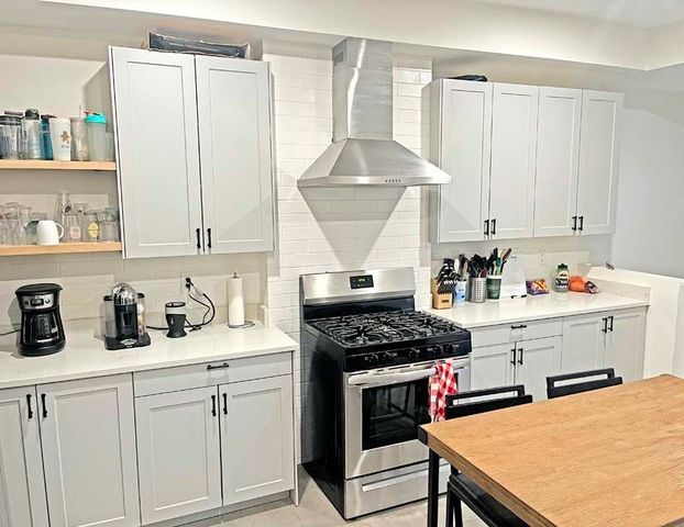 a kitchen with a stove a refrigerator and a sink with wooden cabinets