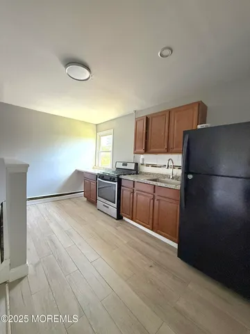 a kitchen with granite countertop a refrigerator and a stove top oven